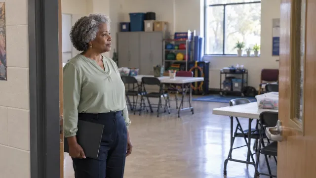 A community organization leader looks into a room being prepared for a program.