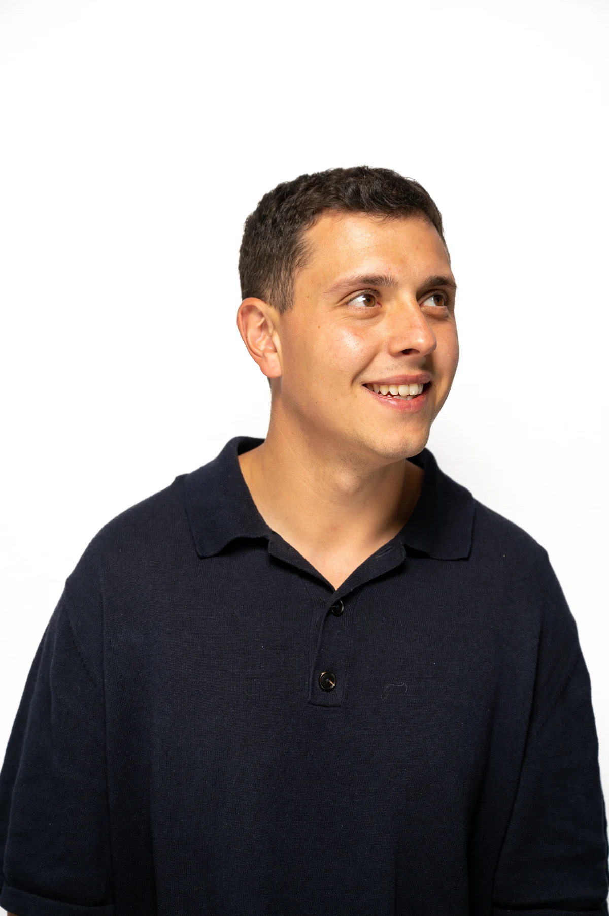 A Visory team member in a navy shirt smiles and looks to the side.