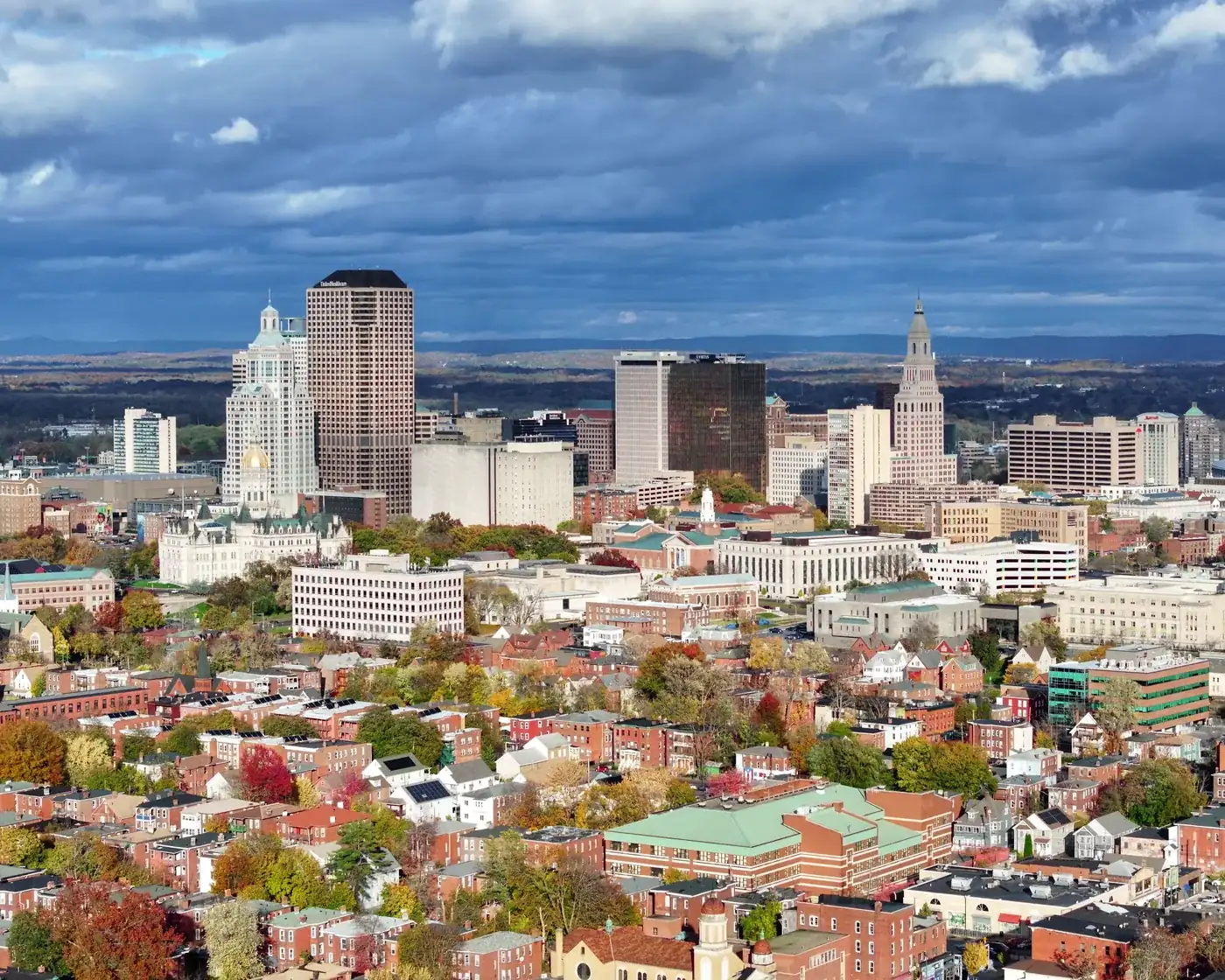 Hartford’s downtown towers, the Travelers Tower and the gold dome of the State Capitol above red-brick streets in autumn.