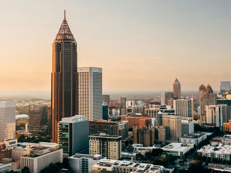 Atlanta’s skyline in golden-hour light, led by the spire of Bank of America Plaza.