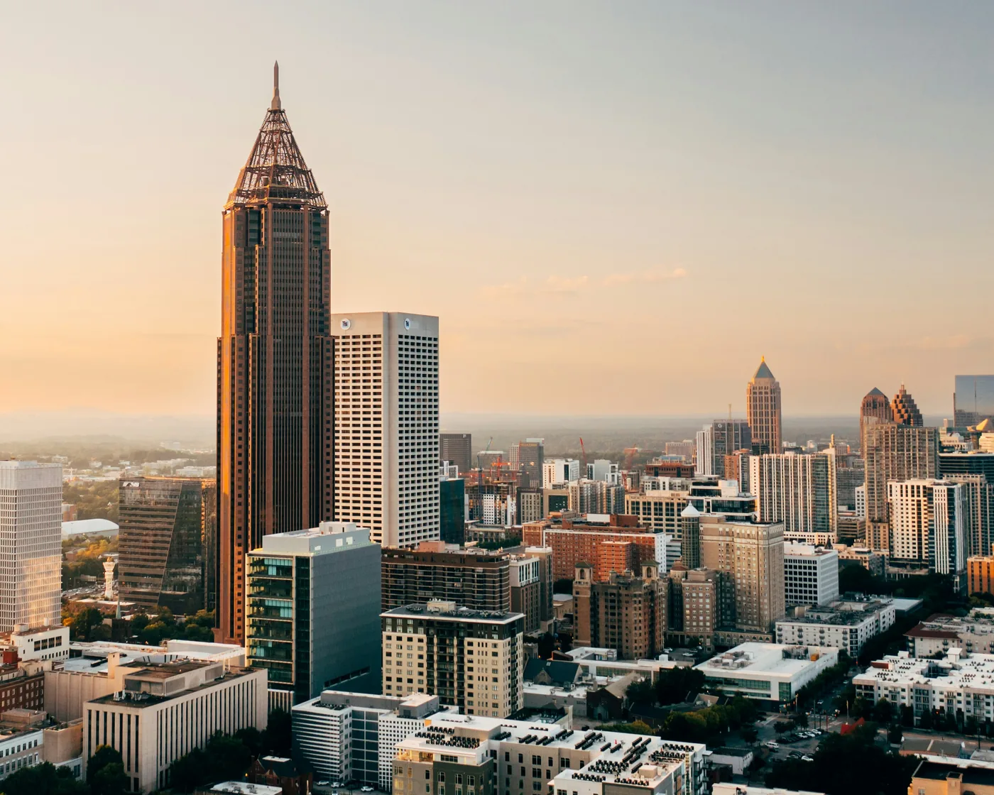 Atlanta’s skyline in golden-hour light, led by the spire of Bank of America Plaza.