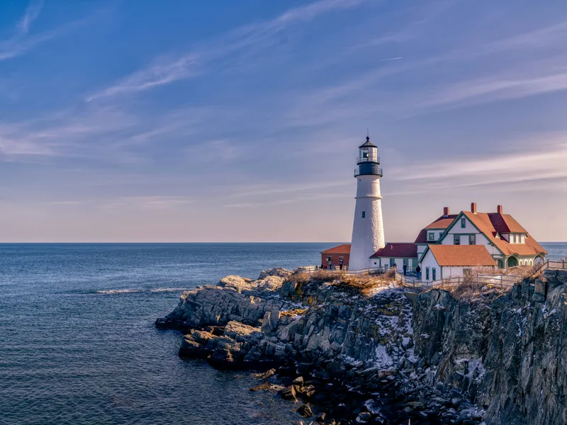 Portland Head Light and its keeper’s house on the rocky shore of Cape Elizabeth, near Portland, in late afternoon light.