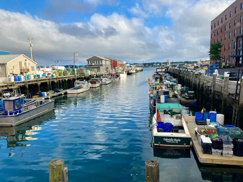 Fishing boats along a wharf on Portland’s working waterfront, with the Old Port behind.