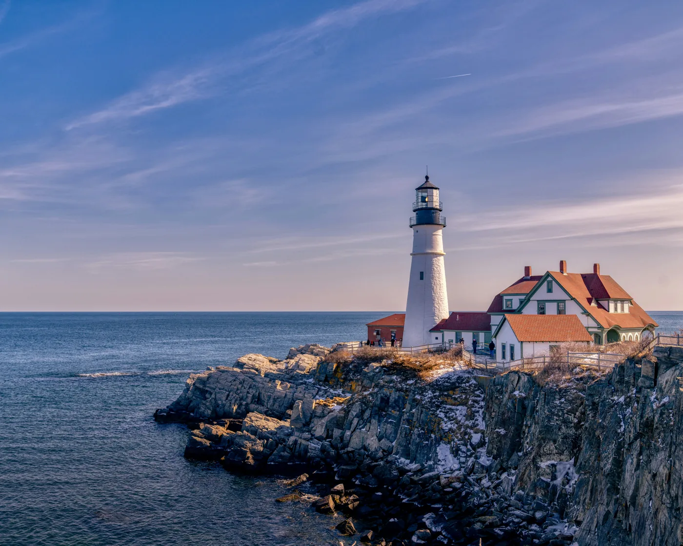 Portland Head Light and its keeper’s house on the rocky shore of Cape Elizabeth, near Portland, in late afternoon light.