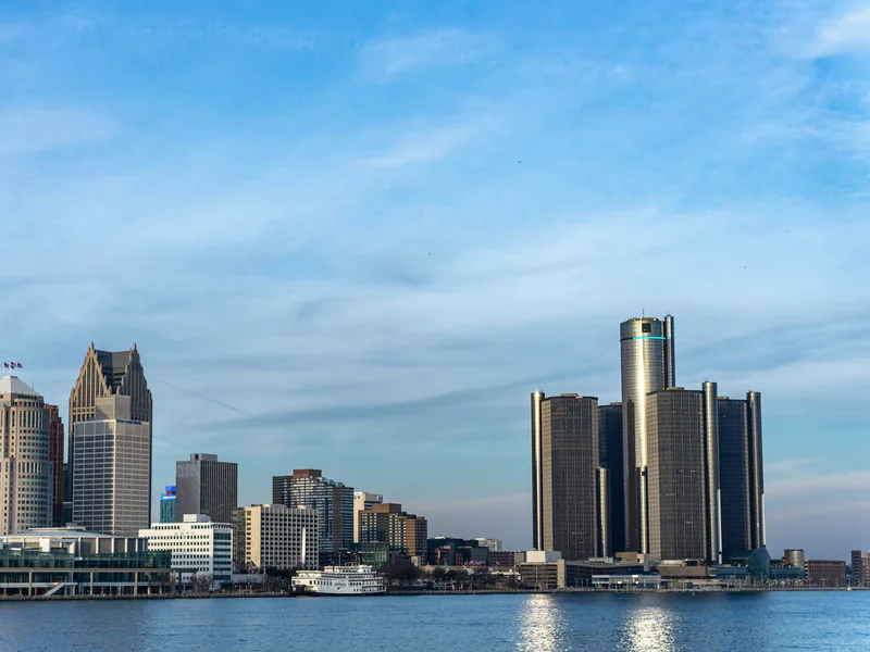 Detroit’s riverfront skyline, with the Renaissance Center and the Penobscot Building, across the Detroit River on a clear afternoon.