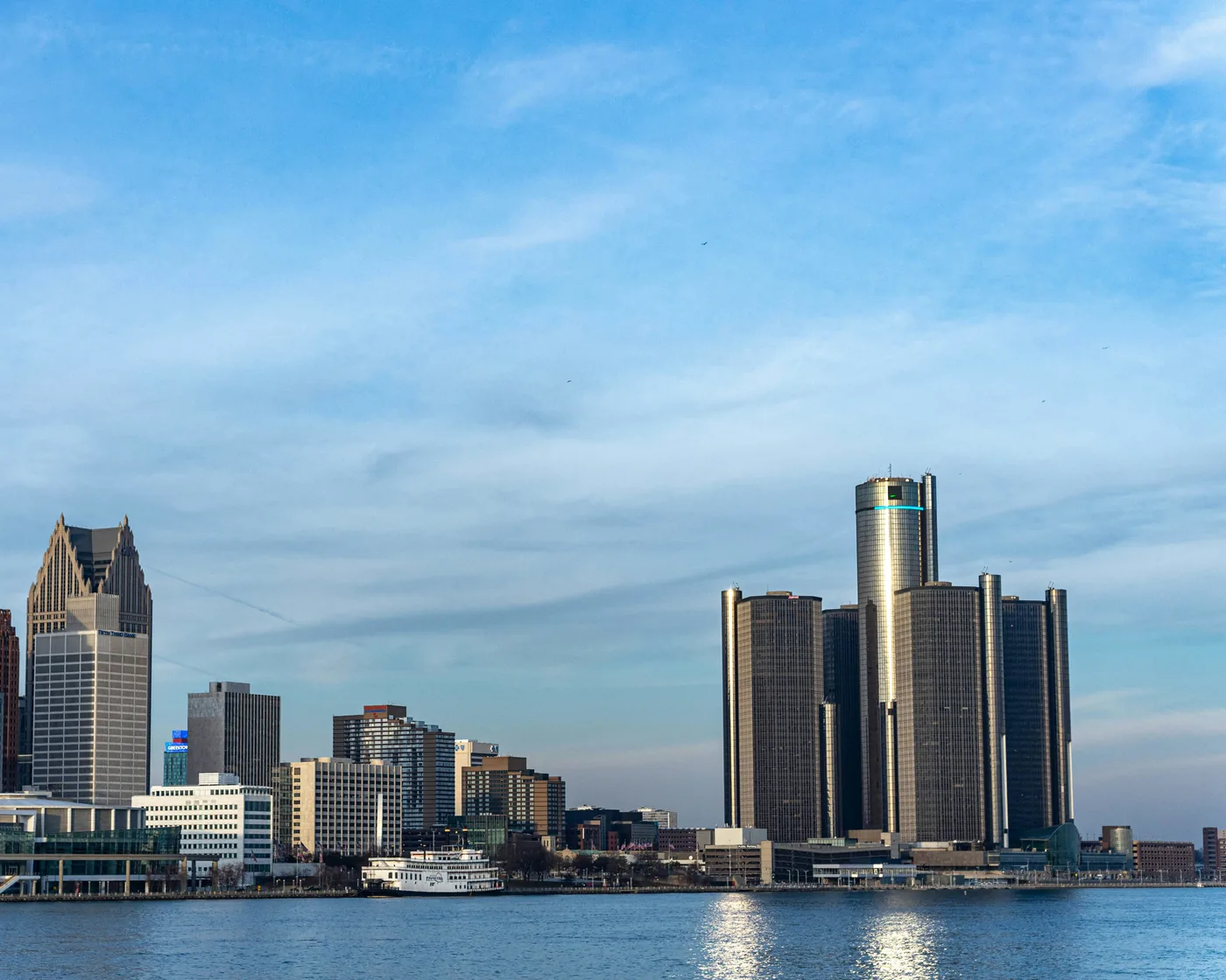 Detroit’s riverfront skyline, with the Renaissance Center and the Penobscot Building, across the Detroit River on a clear afternoon.