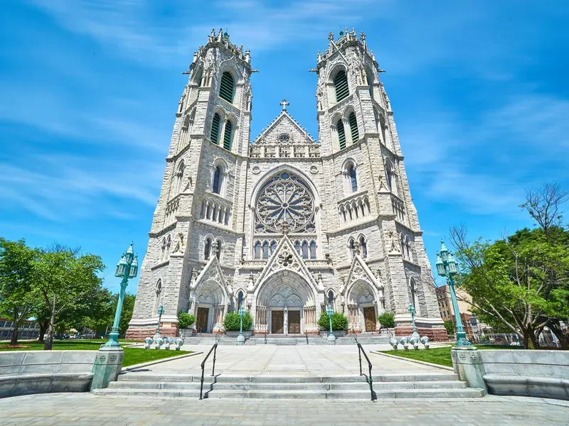 The twin towers and rose window of the Cathedral Basilica of the Sacred Heart in Newark under a clear blue sky.