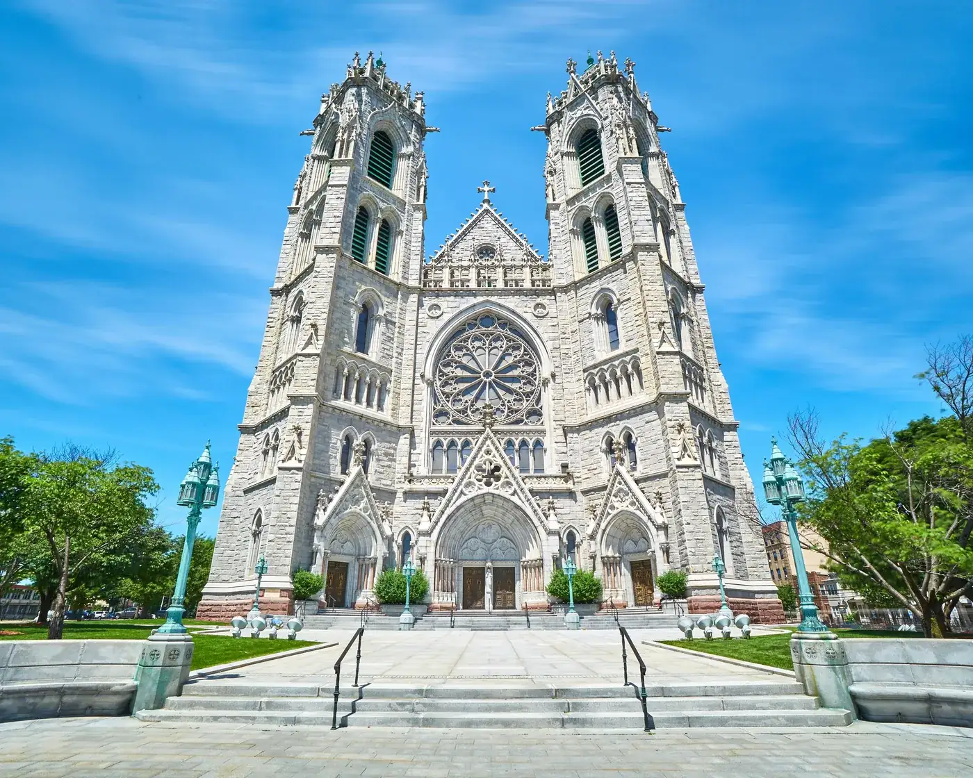 The twin towers and rose window of the Cathedral Basilica of the Sacred Heart in Newark under a clear blue sky.