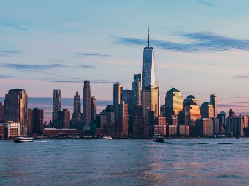 Lower Manhattan’s skyline and One World Trade Center across the Hudson River at golden hour, seen from Hoboken.