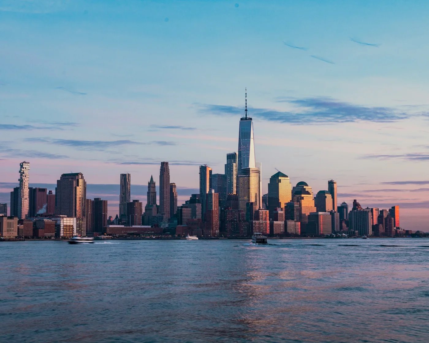Lower Manhattan’s skyline and One World Trade Center across the Hudson River at golden hour, seen from Hoboken.
