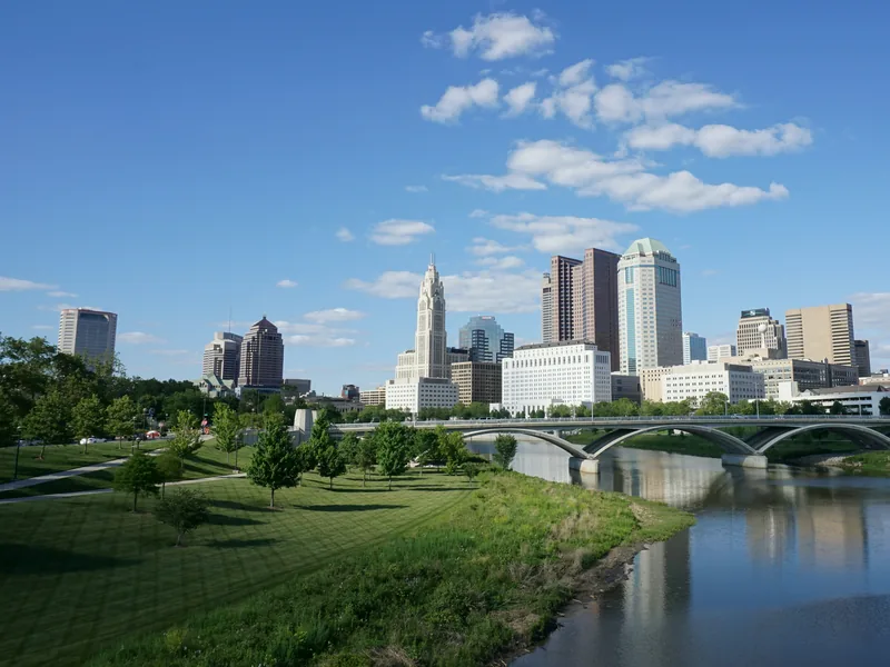Downtown Columbus and the LeVeque Tower above the Scioto River and the Scioto Mile parkland, seen from the Main Street Bridge.