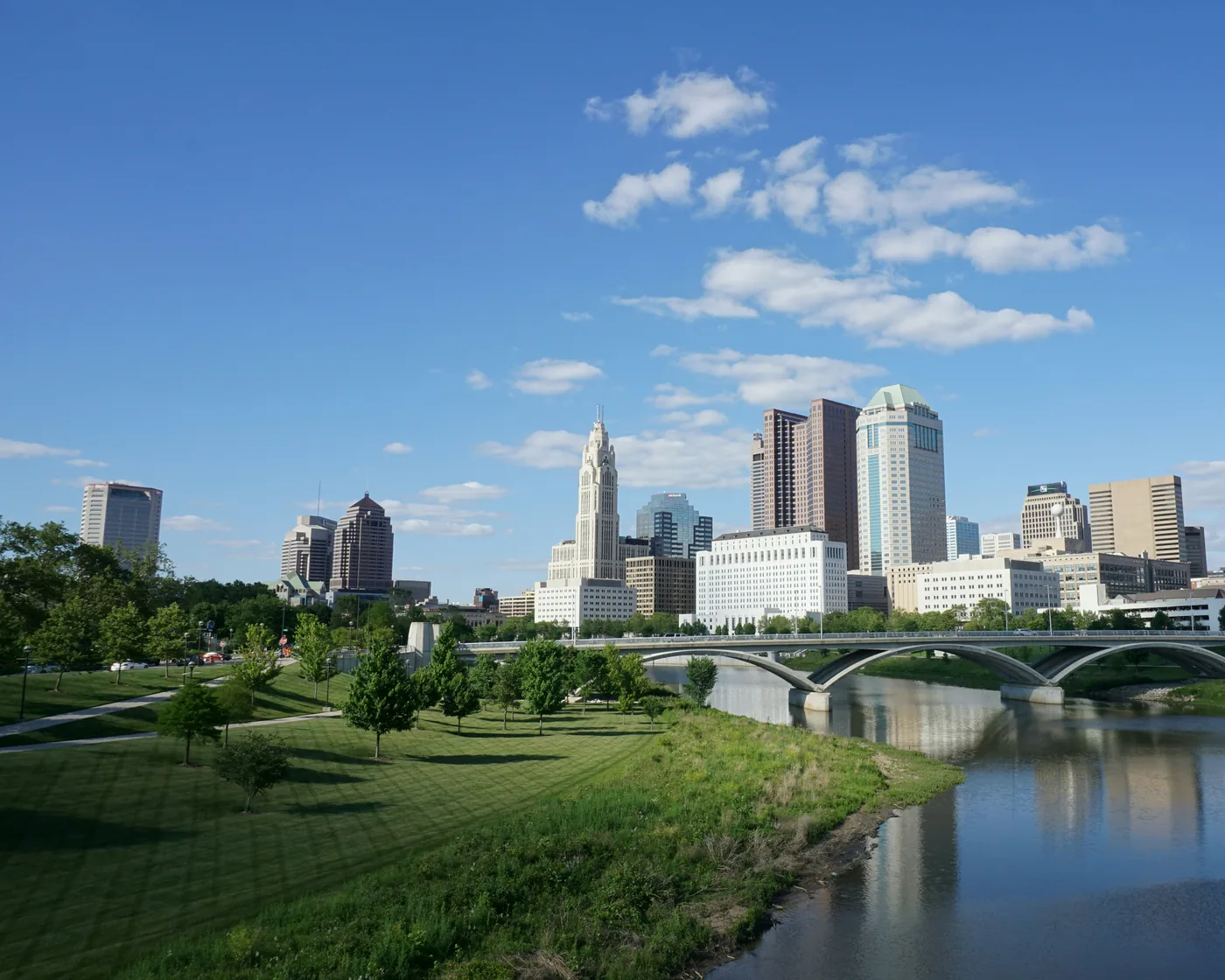 Downtown Columbus and the LeVeque Tower above the Scioto River and the Scioto Mile parkland, seen from the Main Street Bridge.
