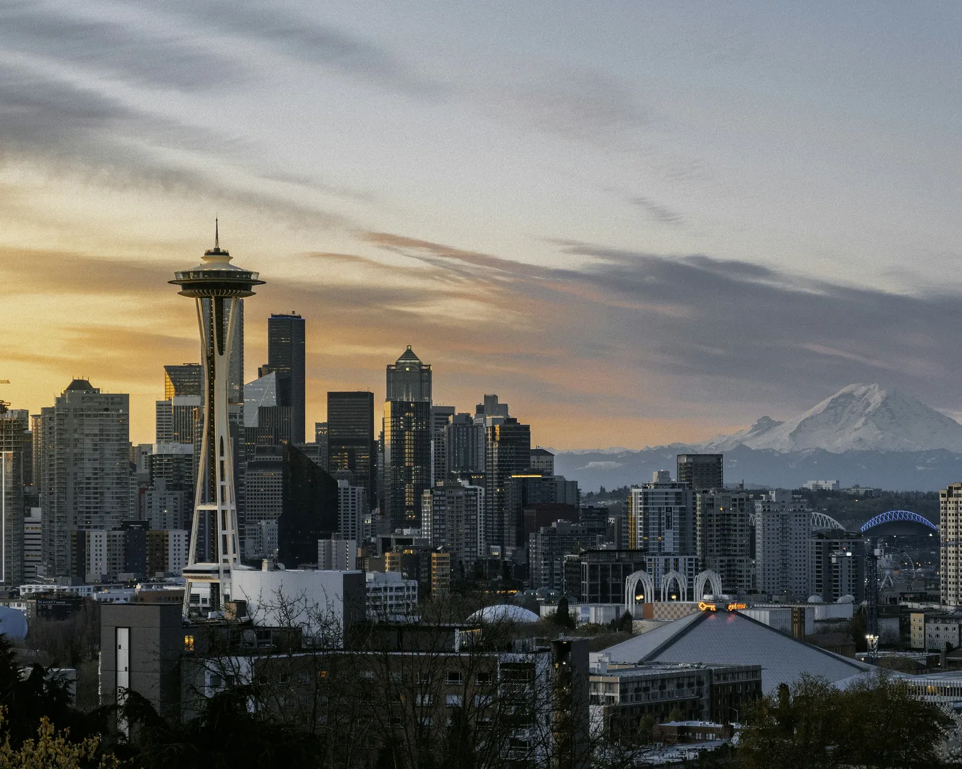The Space Needle and downtown Seattle under a golden sky, with Mount Rainier on the horizon, from Kerry Park.