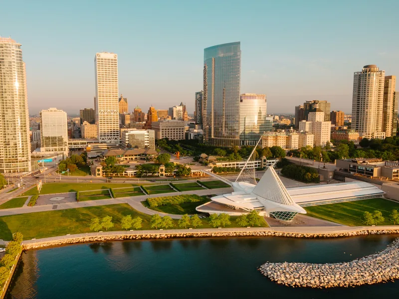 Downtown Milwaukee at sunrise, with the winged Milwaukee Art Museum and the lakefront parks along Lake Michigan.