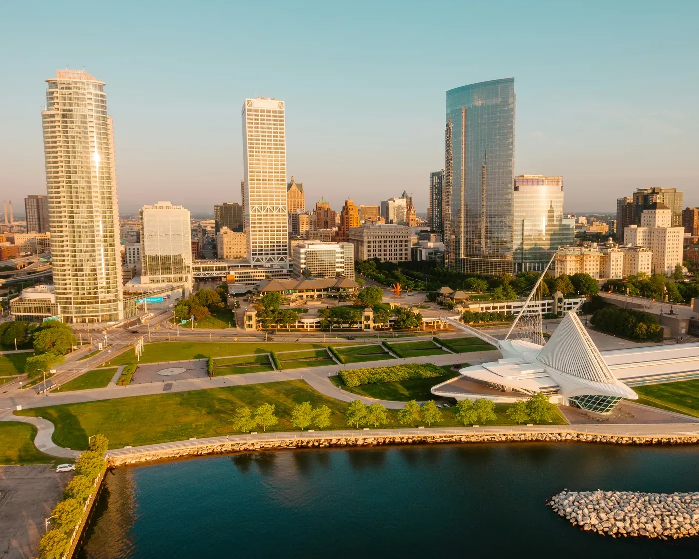 Downtown Milwaukee at sunrise, with the winged Milwaukee Art Museum and the lakefront parks along Lake Michigan.