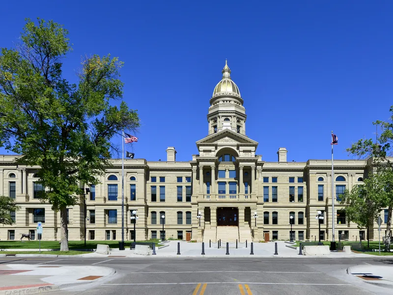 The Wyoming State Capitol in Cheyenne, with its gold dome under a clear blue summer sky.