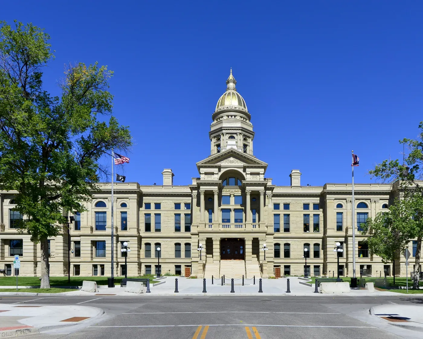 The Wyoming State Capitol in Cheyenne, with its gold dome under a clear blue summer sky.